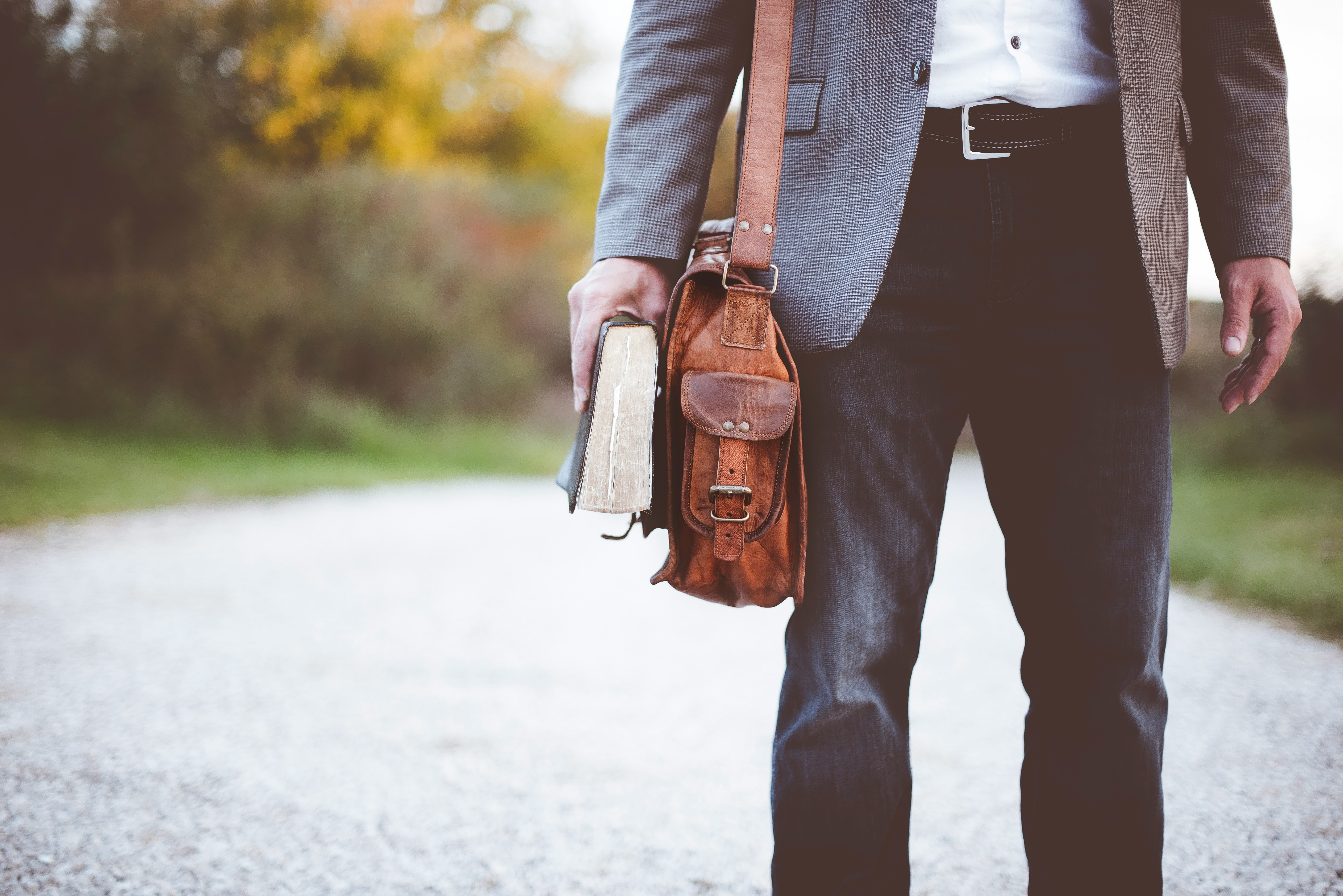 Header image for Careers page - a man walking down a road with a book and satchel